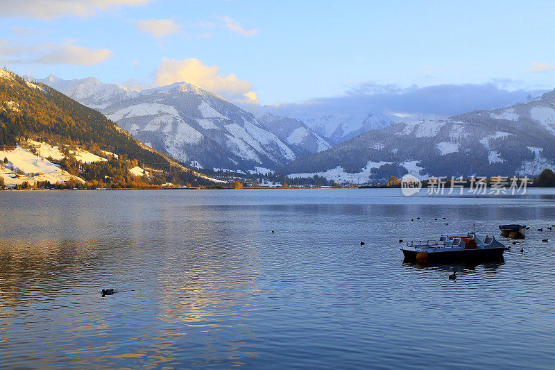 孤独的红船和鸭子漂浮在美丽的泽勒湖上-泽尔am See和山脉景观，Tirol风景在奥地利萨尔茨堡，奥地利